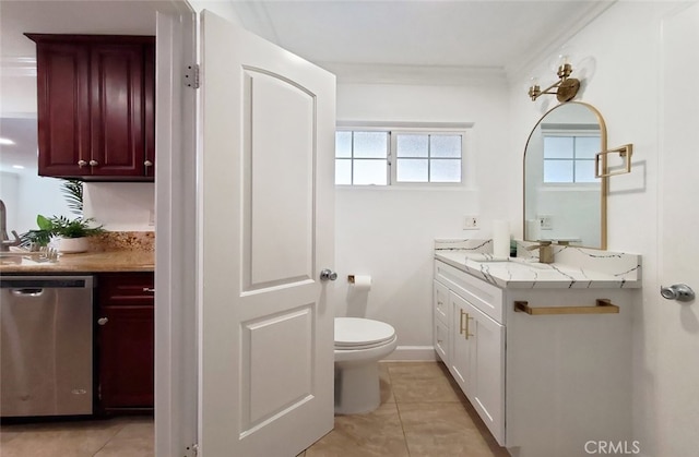 bathroom with toilet, crown molding, vanity, and tile patterned floors