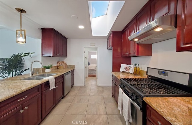 kitchen featuring dark brown cabinets, under cabinet range hood, a sink, and appliances with stainless steel finishes