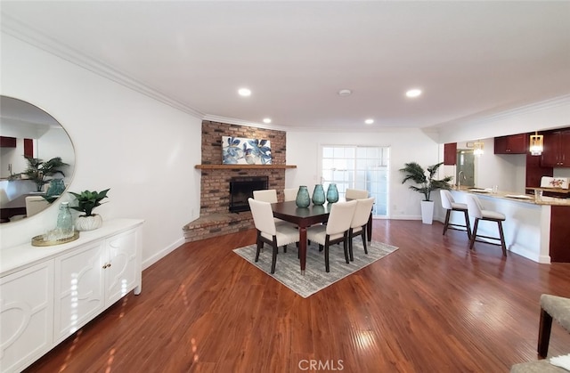 dining area with baseboards, ornamental molding, and a brick fireplace