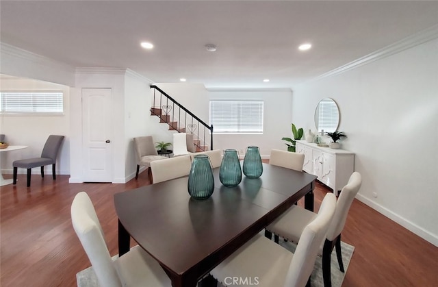 dining area featuring baseboards, crown molding, wood finished floors, and stairs