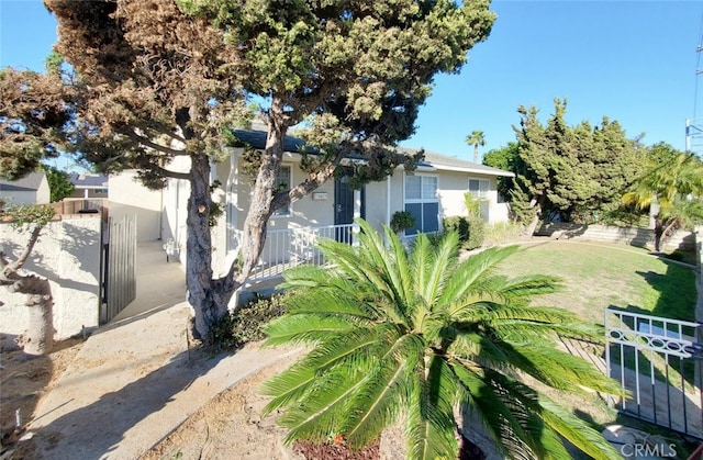 view of property exterior featuring a yard, fence, and stucco siding