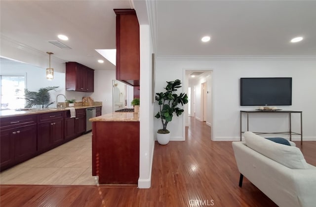kitchen with dark brown cabinets, light stone countertops, visible vents, and crown molding