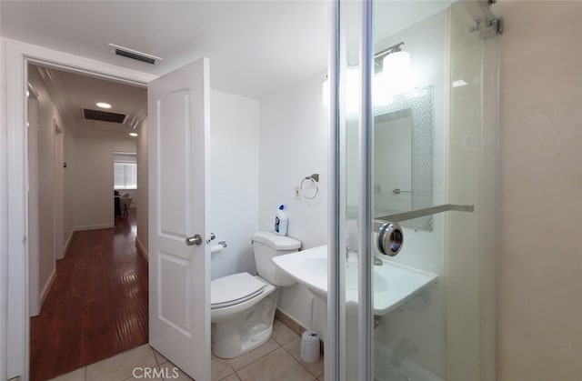 bathroom featuring toilet, wood finished floors, visible vents, and baseboards