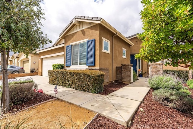 view of front of home featuring concrete driveway, an attached garage, and stucco siding