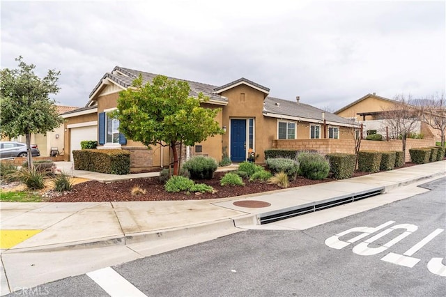 single story home with fence, a garage, and stucco siding