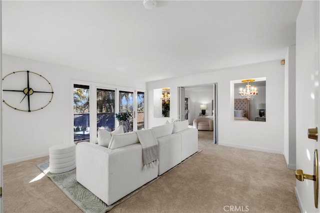 living area featuring light carpet, baseboards, and a notable chandelier