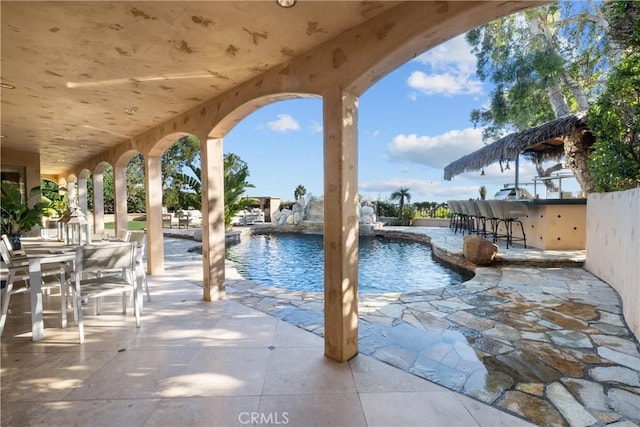 outdoor pool with outdoor dry bar and a patio