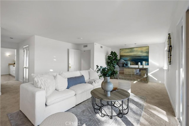 carpeted living area featuring visible vents and baseboards