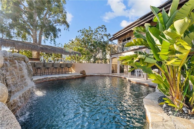 view of pool featuring a fenced in pool, a patio, fence, and exterior bar