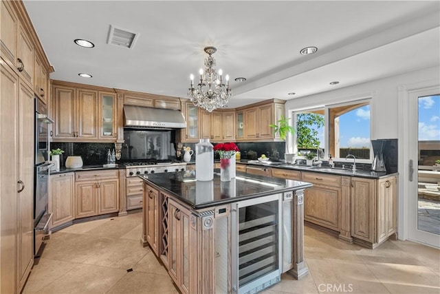 kitchen featuring wall chimney exhaust hood, glass insert cabinets, beverage cooler, and a center island