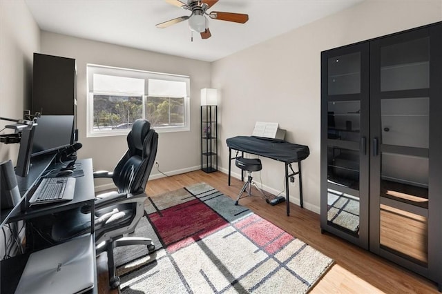 home office with ceiling fan, baseboards, and wood finished floors