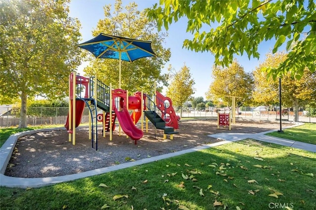 community play area featuring a lawn and fence