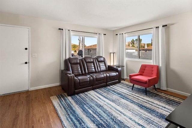 living room featuring a healthy amount of sunlight, baseboards, and wood finished floors