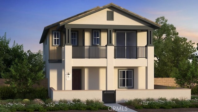 view of front of house with a balcony and stucco siding