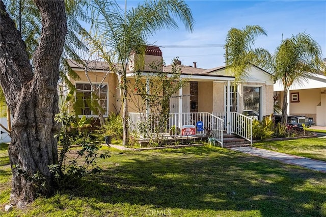 view of front of property with a front yard and stucco siding