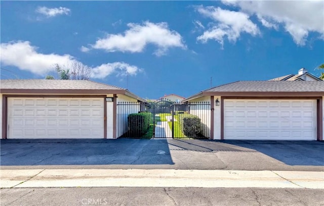 view of front of home featuring a gate, a detached garage, and fence