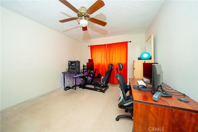 office area featuring light carpet, ceiling fan, and a textured ceiling