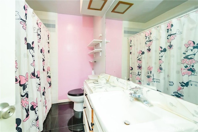 bathroom with toilet, vanity, and tile patterned floors