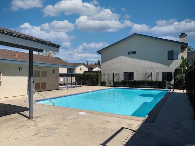 pool with fence and a patio