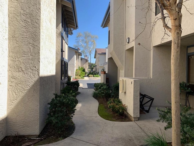 view of side of home with a patio area, a residential view, and stucco siding