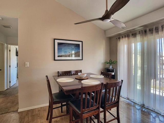 dining space featuring lofted ceiling, ceiling fan, wood finished floors, visible vents, and baseboards