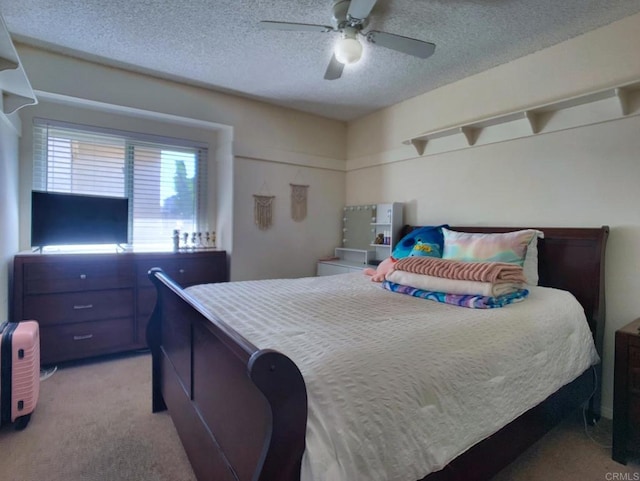 bedroom featuring a ceiling fan, light carpet, and a textured ceiling