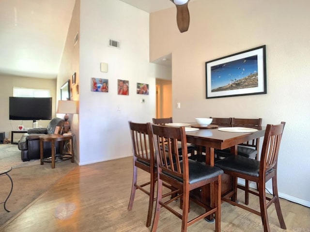 dining area with wood finished floors, visible vents, and baseboards