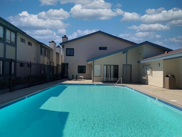 pool with fence and a patio