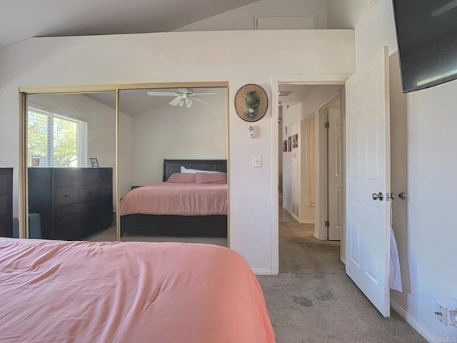 bedroom with lofted ceiling, a closet, carpet flooring, and baseboards