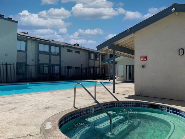 pool with a community hot tub, fence, and a patio