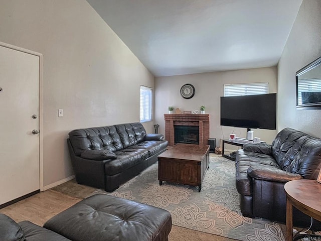 living room featuring a brick fireplace, baseboards, and vaulted ceiling