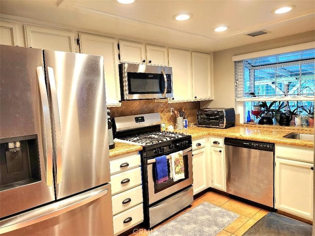 kitchen featuring white cabinets, visible vents, appliances with stainless steel finishes, and light countertops