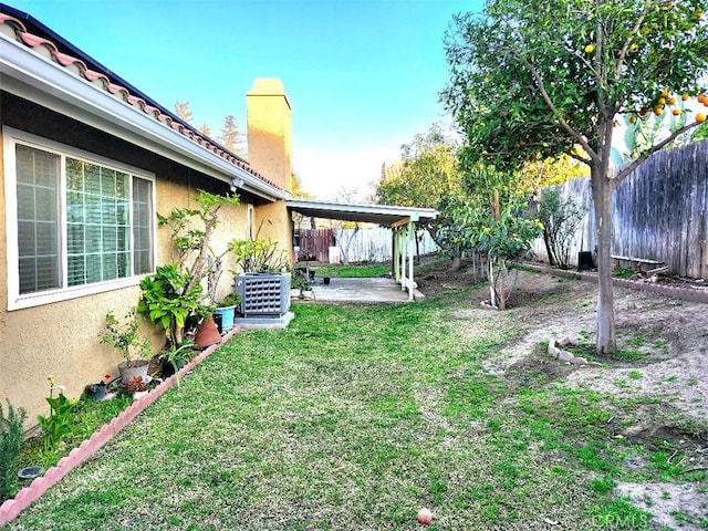 view of yard featuring fence, central AC unit, and a patio