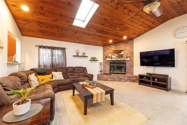 living area with wooden ceiling, light colored carpet, a fireplace, a ceiling fan, and lofted ceiling with skylight