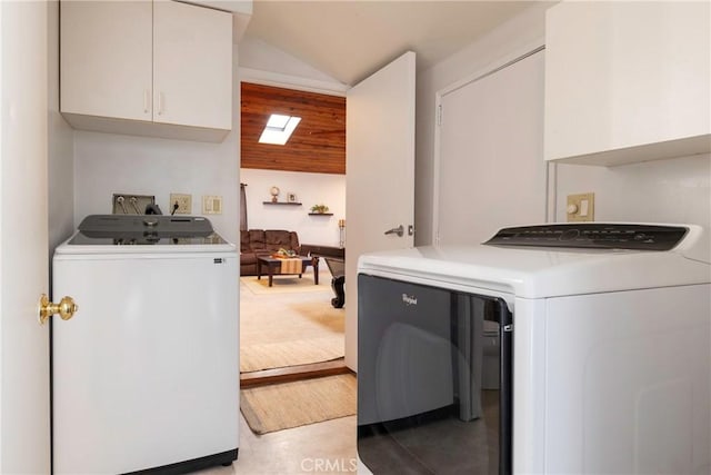 laundry area featuring a skylight, cabinet space, and washer and dryer