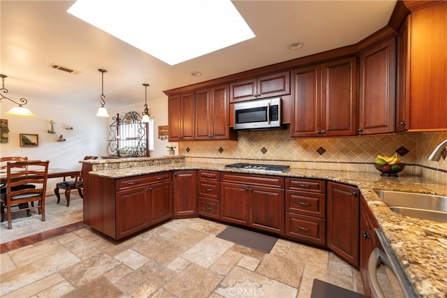 kitchen with appliances with stainless steel finishes, pendant lighting, visible vents, and a sink