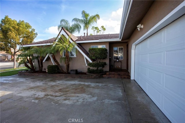 exterior space featuring an attached garage and stucco siding