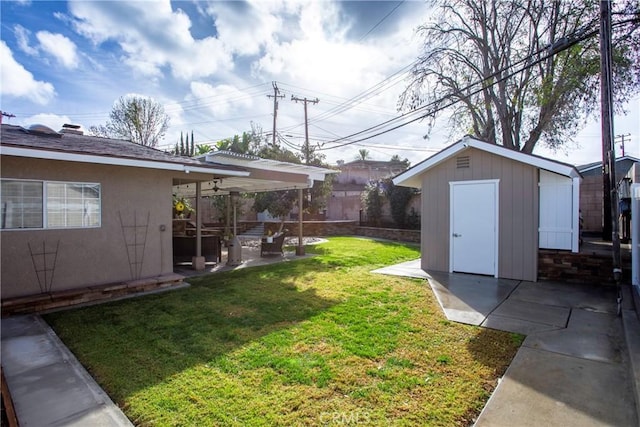 view of yard featuring a patio area, an outdoor structure, and a shed