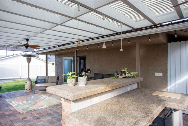 view of patio / terrace featuring exterior bar, ceiling fan, fence, an outdoor living space, and a pergola