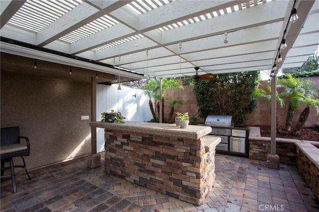 view of patio with a fenced backyard, area for grilling, an outdoor kitchen, and a pergola