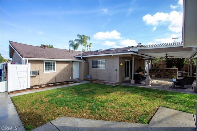 ranch-style home featuring ceiling fan, a patio, stucco siding, a pergola, and a front yard