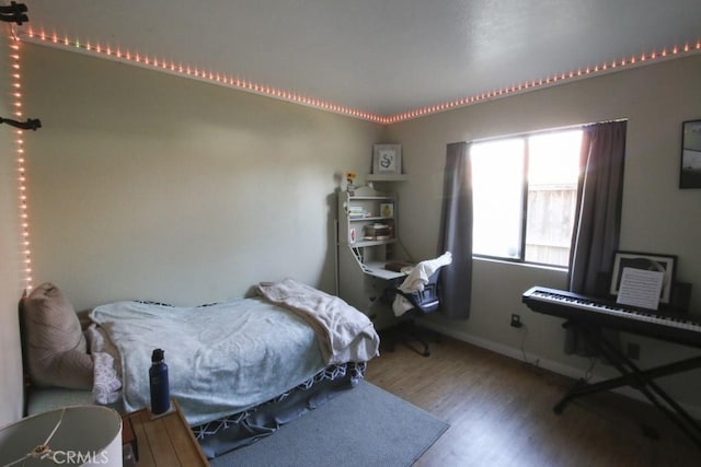 bedroom featuring wood finished floors and baseboards