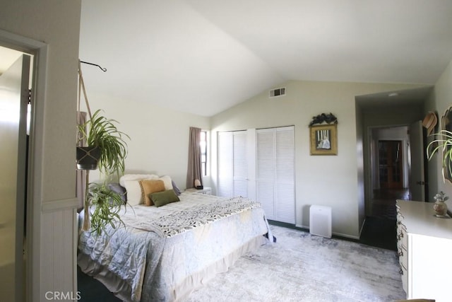 bedroom with visible vents, vaulted ceiling, and light carpet