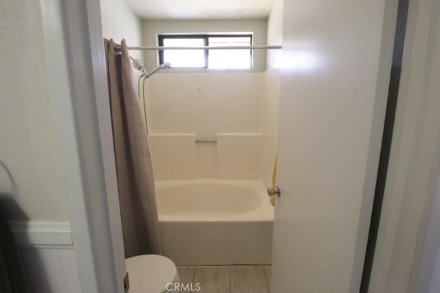 bathroom featuring toilet and shower / bath combo with shower curtain