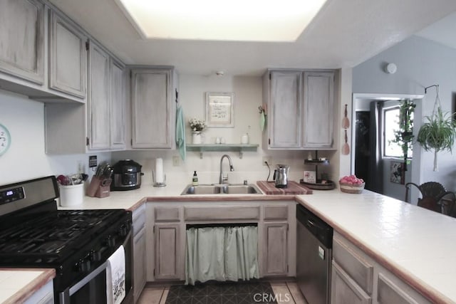 kitchen featuring a sink, light countertops, appliances with stainless steel finishes, tile patterned floors, and open shelves