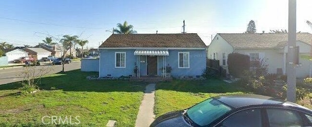 bungalow with a front yard and stucco siding