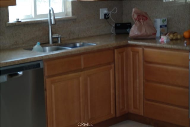 kitchen with decorative backsplash, light countertops, a sink, and stainless steel dishwasher