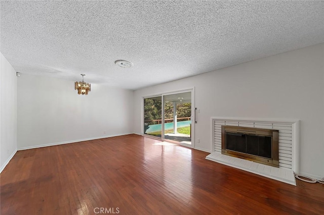 unfurnished living room featuring a fireplace, baseboards, and wood finished floors