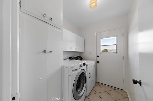 laundry area featuring cabinet space, independent washer and dryer, and light tile patterned floors