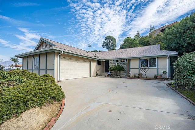 ranch-style home featuring an attached garage, concrete driveway, and stucco siding